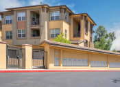 Thumbnail 4 of 80 - an apartment building with a garage on a sunny day