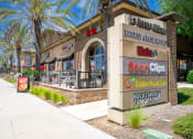Thumbnail 17 of 80 - a restaurant exterior with palm trees and a sidewalk in front of it