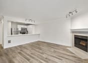 Thumbnail 38 of 73 - a living room with a fireplace and a kitchen in the background at Lakemont Orchard, Issaquah, 98027  