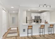 Thumbnail 31 of 73 - a kitchen with a breakfast bar, bar stool, white cabinetry and stainless appliances at Lakemont Orchard, Issaquah, WA  