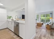 Thumbnail 55 of 73 - a kitchen with a sink and a dishwasher and a living room with a couch at Lakemont Orchard, Washington, 98027