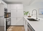 Thumbnail 56 of 73 - a white kitchen with white cabinets and a sink at Lakemont Orchard, Issaquah, WA 98027  