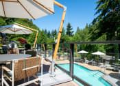 Thumbnail 59 of 73 - a view of a swimming pool from a patio with tables and chairs at Lakemont Orchard, Issaquah Washington  