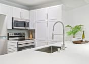 Thumbnail 66 of 73 - a white kitchen with stainless steel appliances and a sink at Lakemont Orchard, Issaquah, WA  