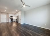 Thumbnail 79 of 90 - A spacious room with a kitchen area and a ceiling fan.