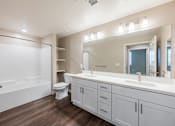 Thumbnail 78 of 90 - A bathroom with a white tub, toilet, and sink.