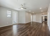 Thumbnail 85 of 90 - A spacious room with wooden floors and a ceiling fan.