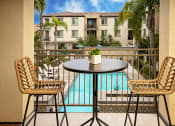 Thumbnail 21 of 72 - a patio with a table and chairs and a pool in the background