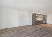 Thumbnail 1 of 26 - A kitchen area with a wooden floor and a white wall at Wilshire Valencia Apartment, Los Angeles, California
