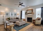 Thumbnail 14 of 39 - Living Room With Tan Couch, Area Rug, Fireplace, Two Windows, And A Ceiling Fan at McDermott Place, Plano