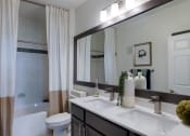 Thumbnail 17 of 39 - athroom With Double Sinks, Large Mirror, And Tile Bathtub Backsplash a bathtub at McDermott Place, Texas