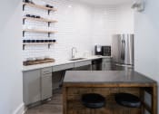 Thumbnail 36 of 39 - A kitchen with a bar stool and a refrigerator at McDermott Place, Plano, TX 75025