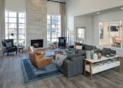 Thumbnail 31 of 39 - A modern living room with a stone fireplace and a chandelier at McDermott Place, Plano, 75025