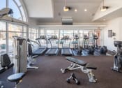 Thumbnail 32 of 39 - A gym with a variety of equipment including treadmills, weights, and exercise machines at McDermott Place, Plano, Texas