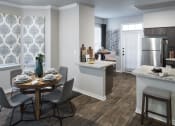 Thumbnail 26 of 39 - Dining Area with Wood-Style Flooring, Table, Chairs, Granite Countertops, View of Kitchen, and Nine-Foot Ceilings with Crown Molding at McDermott Place, Texas