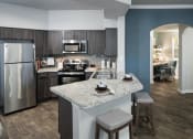 Thumbnail 27 of 39 - Chef-Inspired Kitchen with Wood-Style Flooring, Stainless Steel Appliances, Breakfast Bar with Barstools, and Wood-Tone Cabinets at McDermott Place, Plano