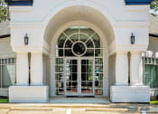 Thumbnail 21 of 39 - a white building with a glass door and a blue roof at McDermott Place, Plano