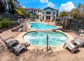 Thumbnail 16 of 78 - our apartments have a resort style pool and spa with chairs at Miro at the Parc, Henderson, NV