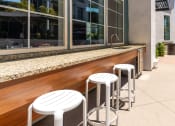 Thumbnail 20 of 78 - a bar with three white stools in front of a window at Miro at the Parc, Henderson, 89074
