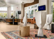 Thumbnail 9 of 78 - the lobby of a building with sculptures and a table and chairs at Miro at the Parc, Henderson, NV 89074