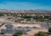 Thumbnail 49 of 78 - an aerial view of a bike park with a city and mountains in the background at Miro at the Parc, Nevada