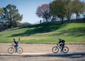 Thumbnail 56 of 78 - two people riding bikes at the park at Miro at the Parc, Henderson, NV 89074