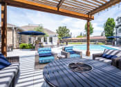 Thumbnail 33 of 36 - Outdoor seating with fire pit table in pool area at Montrachet Apartments, Napa, CA