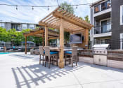 Thumbnail 34 of 36 - BBQ Area Next to Pool with Grill, Countertop, TV, and Stools at Montrachet Apartments, California, 94558