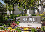 Thumbnail 32 of 34 - A sign for Montrachet Luxury Apartment Homes stands in front of a building.