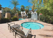 Thumbnail 42 of 67 - Apartments in Chandler, AZ, for Rent - Monument - Hot Tub with Chairs, Palm Trees, and Blue Skies.