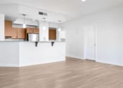Thumbnail 66 of 67 - an empty living room and kitchen with white walls and wood floors