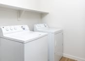 Thumbnail 67 of 67 - a white washer and dryer in a room with white walls and wood floors