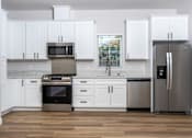 Thumbnail 10 of 44 - Kitchen with grey fridge and cabinet at Nola 624, West Covina, CA