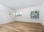 Thumbnail 23 of 44 - A room with wooden flooring and two windows with blinds. at Nola 624, West Covina, CA