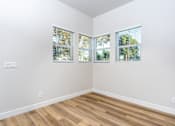 Thumbnail 22 of 44 - A room with wooden floors and two windows with blinds. at Nola 624, West Covina, CA 91790  