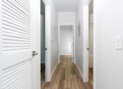 Thumbnail 16 of 44 - A long hallway with white walls and wood floors. at Nola 624, West Covina, CA 91790