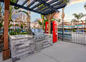 Thumbnail 33 of 44 - A barbecue grill is set up on a patio with a pool in the background. at Nola 624, West Covina, 91790  