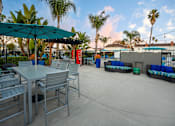 Thumbnail 34 of 44 - A patio with a table and chairs under a green umbrella. at Nola 624, West Covina California