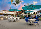 Thumbnail 36 of 44 - A patio with a table and chairs under a blue umbrella. at Nola 624, West Covina California