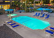 Thumbnail 43 of 44 - A large swimming pool surrounded by blue lounge chairs and umbrellas. at Nola 624, West Covina California