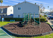 Thumbnail 44 of 44 - A playground with a green slide and brown mulch in the foreground. at Nola 624, West Covina