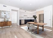 Thumbnail 4 of 52 - A modern kitchen with a dining table and chairs.