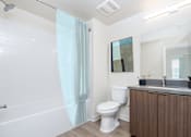 Thumbnail 6 of 52 - A white toilet sits next to a sink in a bathroom.