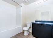 Thumbnail 21 of 52 - A white toilet sits next to a bathtub in a bathroom.