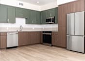 Thumbnail 23 of 52 - A kitchen with a refrigerator, oven, and microwave.