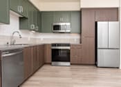 Thumbnail 9 of 52 - A kitchen with wooden cabinets and stainless steel appliances.