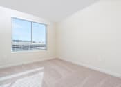 Thumbnail 28 of 52 - A room with a window and carpeted floor.