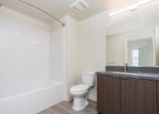 Thumbnail 32 of 52 - A white toilet sits next to a white bathtub in a bathroom.