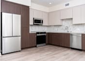 Thumbnail 30 of 52 - A kitchen with white appliances and brown cabinets.