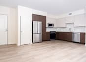 Thumbnail 31 of 52 - A kitchen with white cabinets and a wooden floor.
